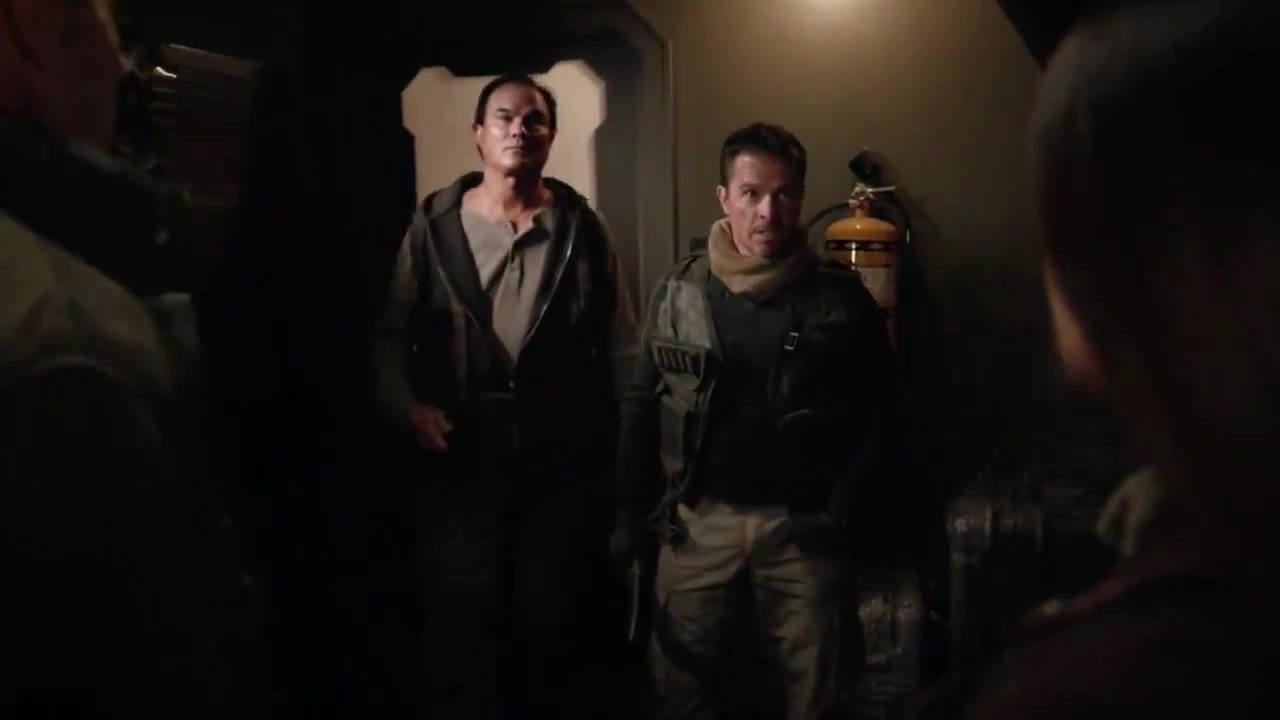 McKay Stewart as Roughneck, in a scarf and tactical vest, standing beside another man in a dark corridor in Agents of S.H.I.E.L.D. "The Last Day"