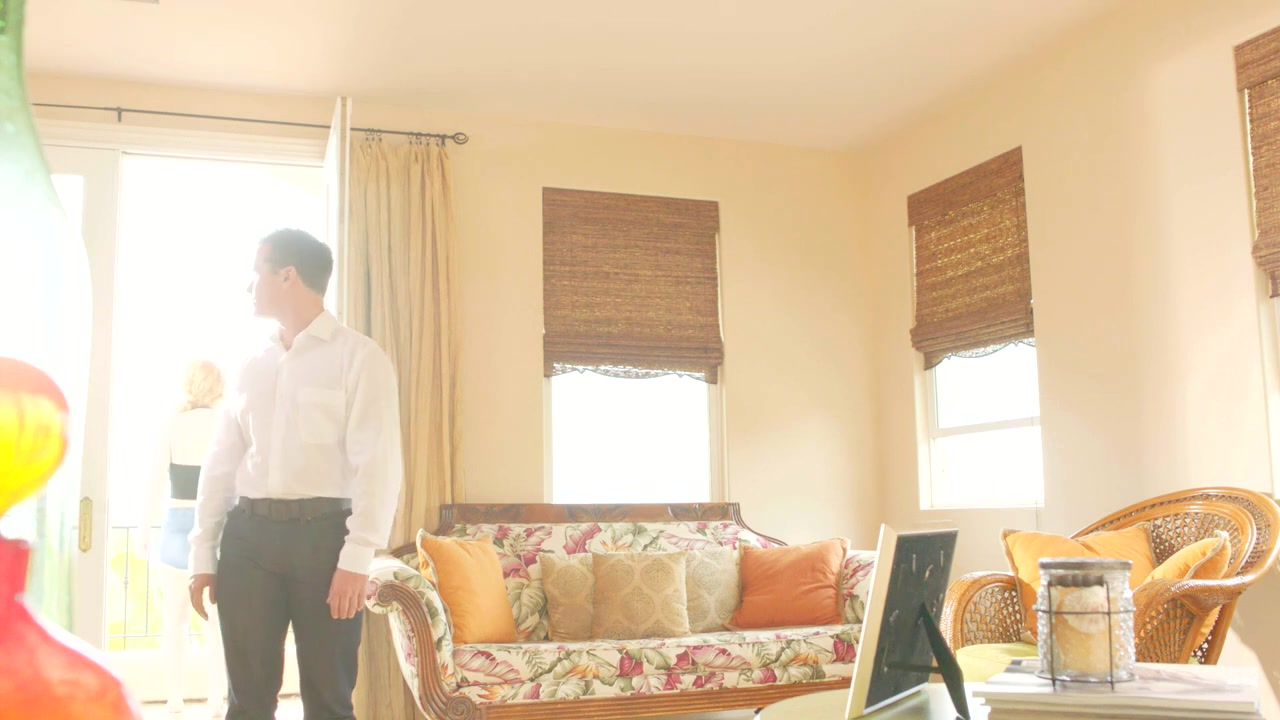 McKay Stewart in a white shirt looking toward a bright balcony in the Never Stop music video