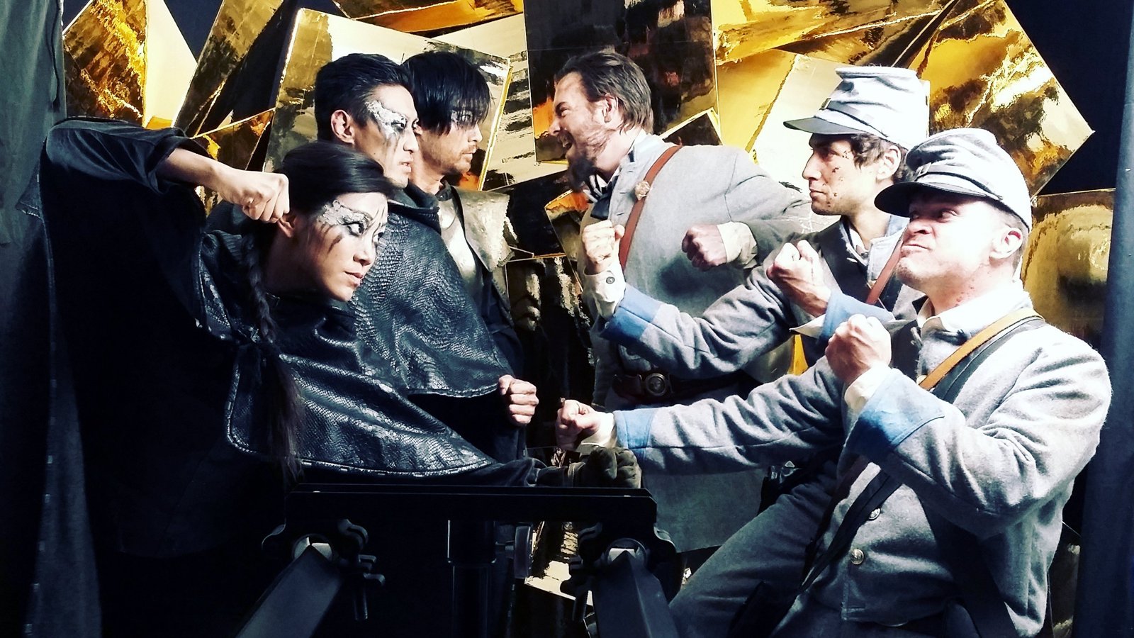 Cast in Confederate gray uniforms face off with Dark Army fighters in black with silver face paint, fists raised, on the Escape the Night set