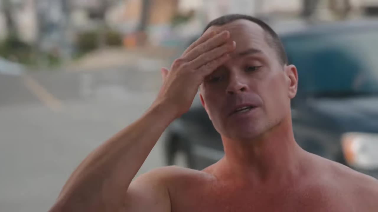 McKay Stewart, shirtless by the car, scratching his head